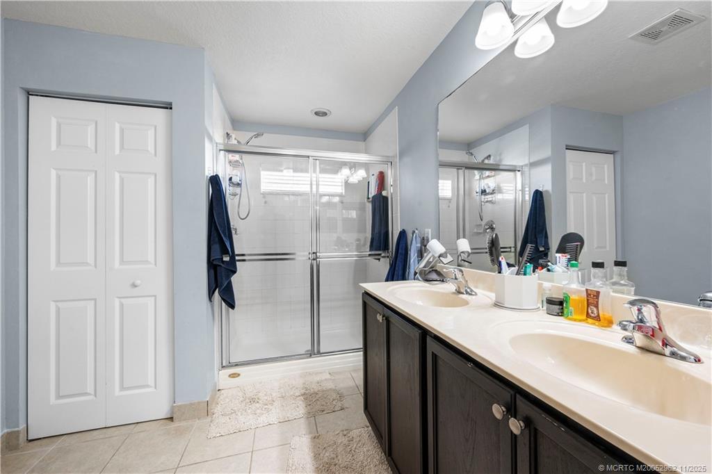 5532 Southeast Graham Drive Stuart, FL 34997 - Photo 19 of 43 a bathroom with a sink a mirror and a shower