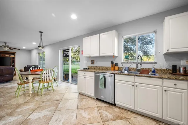 a kitchen with granite countertop a sink cabinets and window