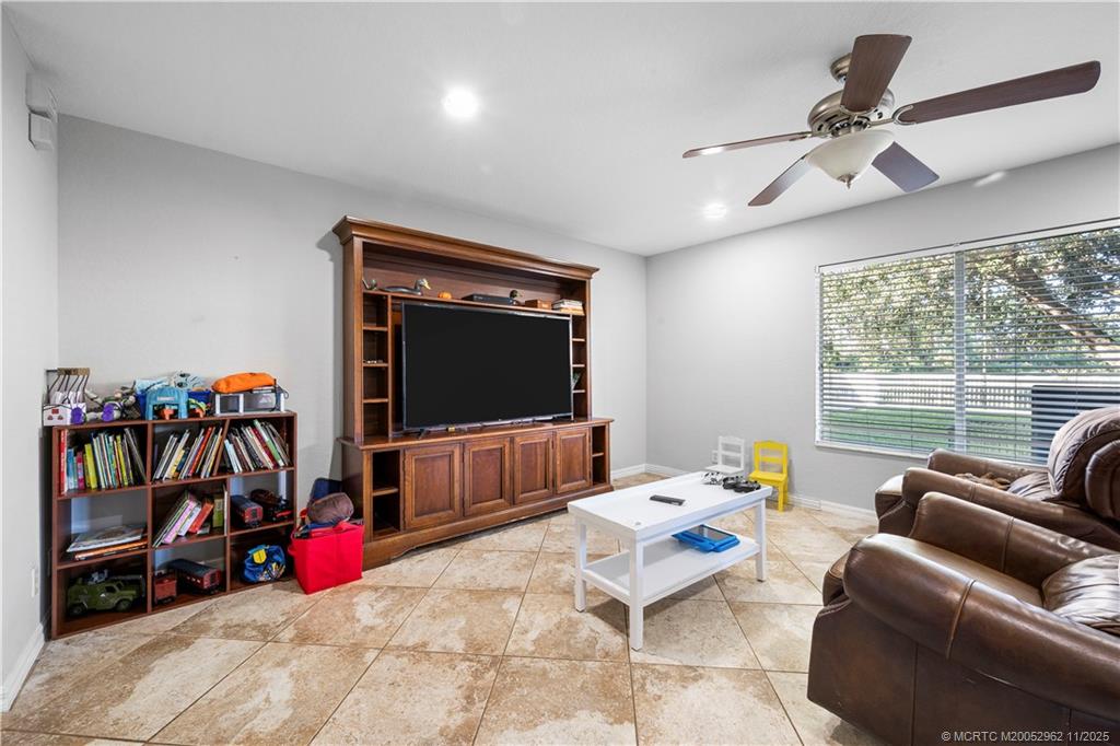 5532 Southeast Graham Drive Stuart, FL 34997 - Photo 8 of 43 a living room with furniture a flat screen tv and a floor to ceiling window