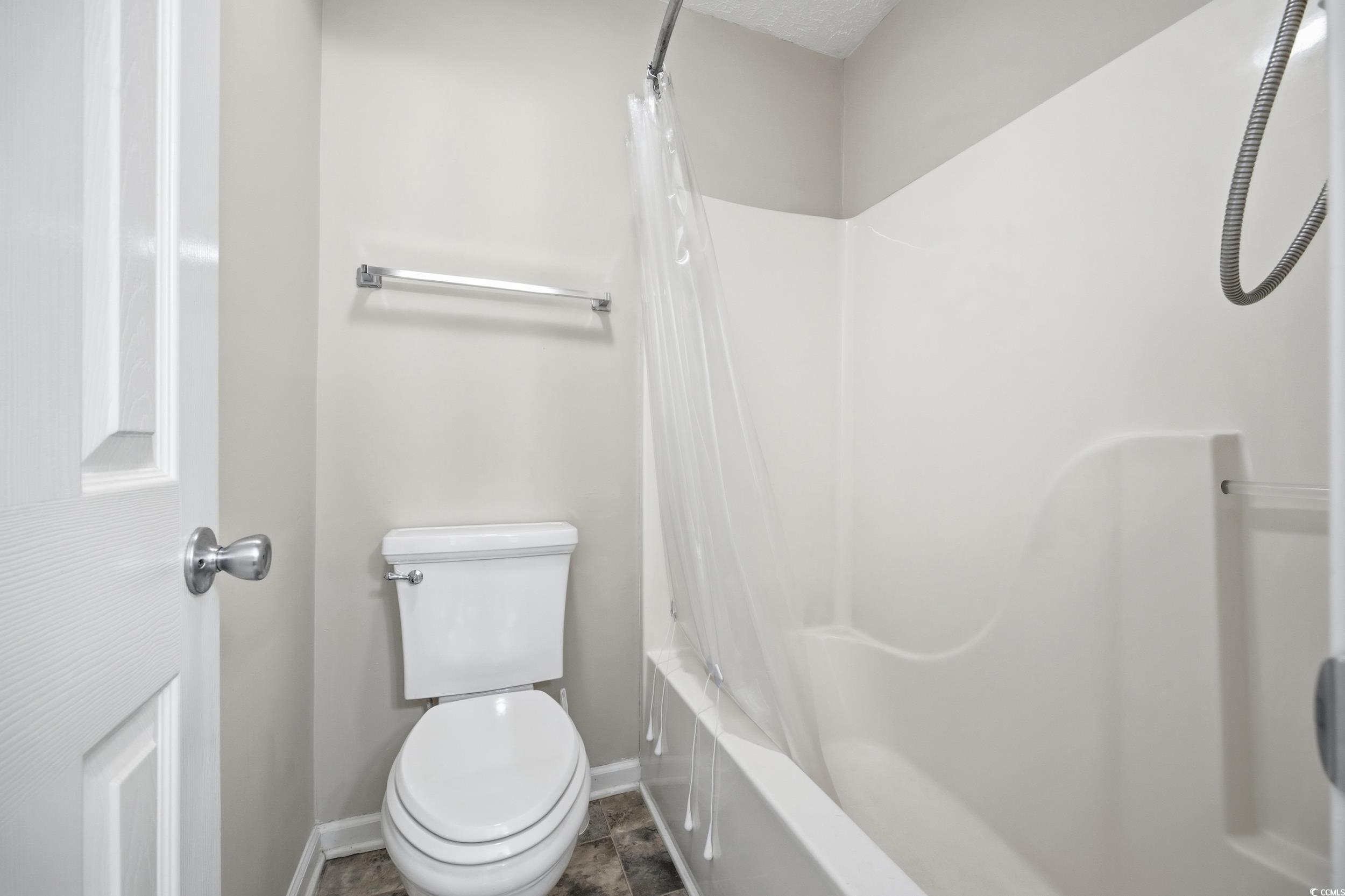 615 Tupelo Lane, Unit F Longs, SC 29568 - Photo 13 of 27 Full bathroom with shower / bath combo with shower curtain and baseboards