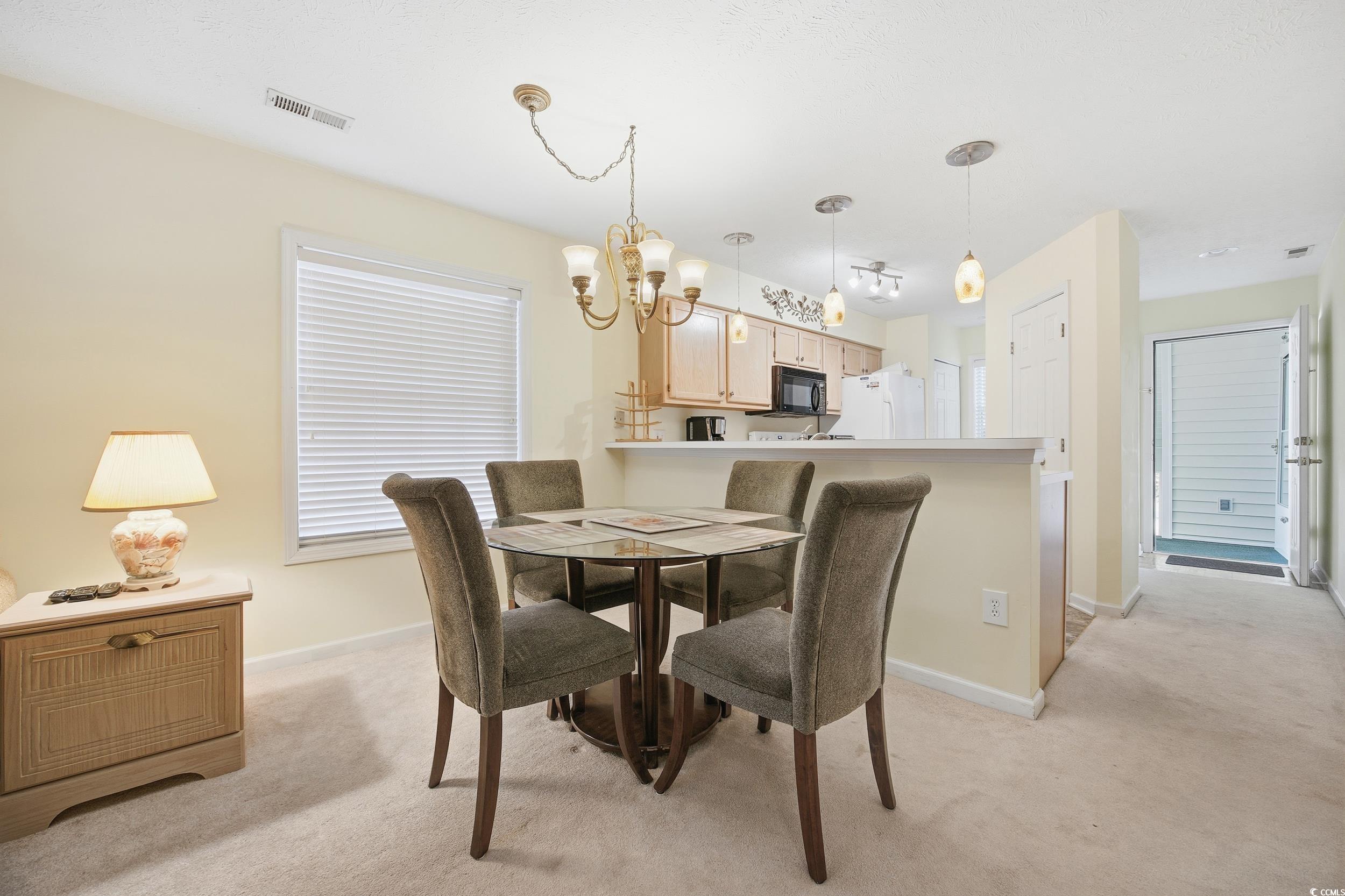 615 Tupelo Lane, Unit F Longs, SC 29568 - Photo 6 of 27 Dining room with light colored carpet and a chandelier