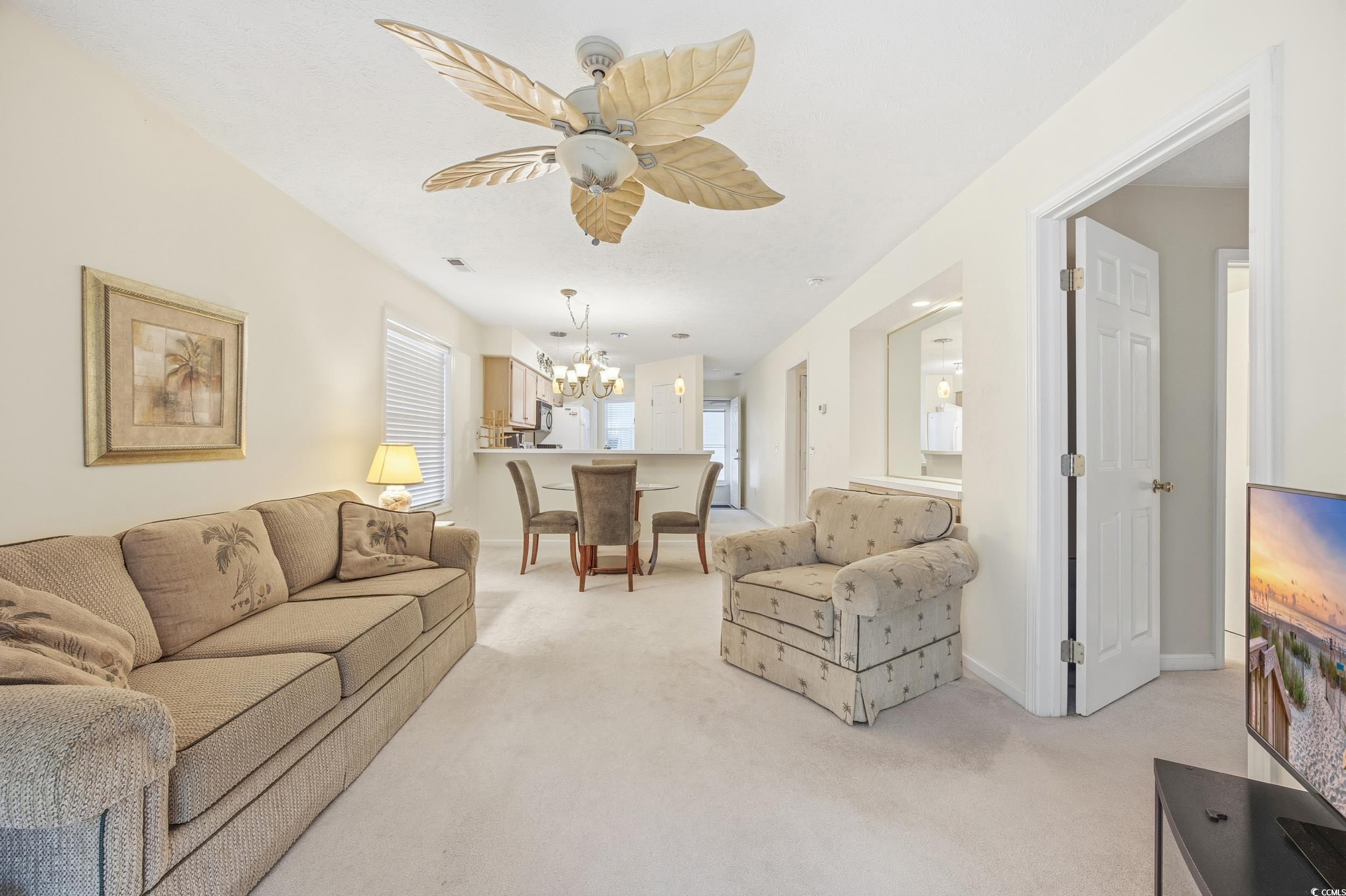 615 Tupelo Lane, Unit F Longs, SC 29568 - Photo 9 of 27 Living room featuring light colored carpet and a chandelier