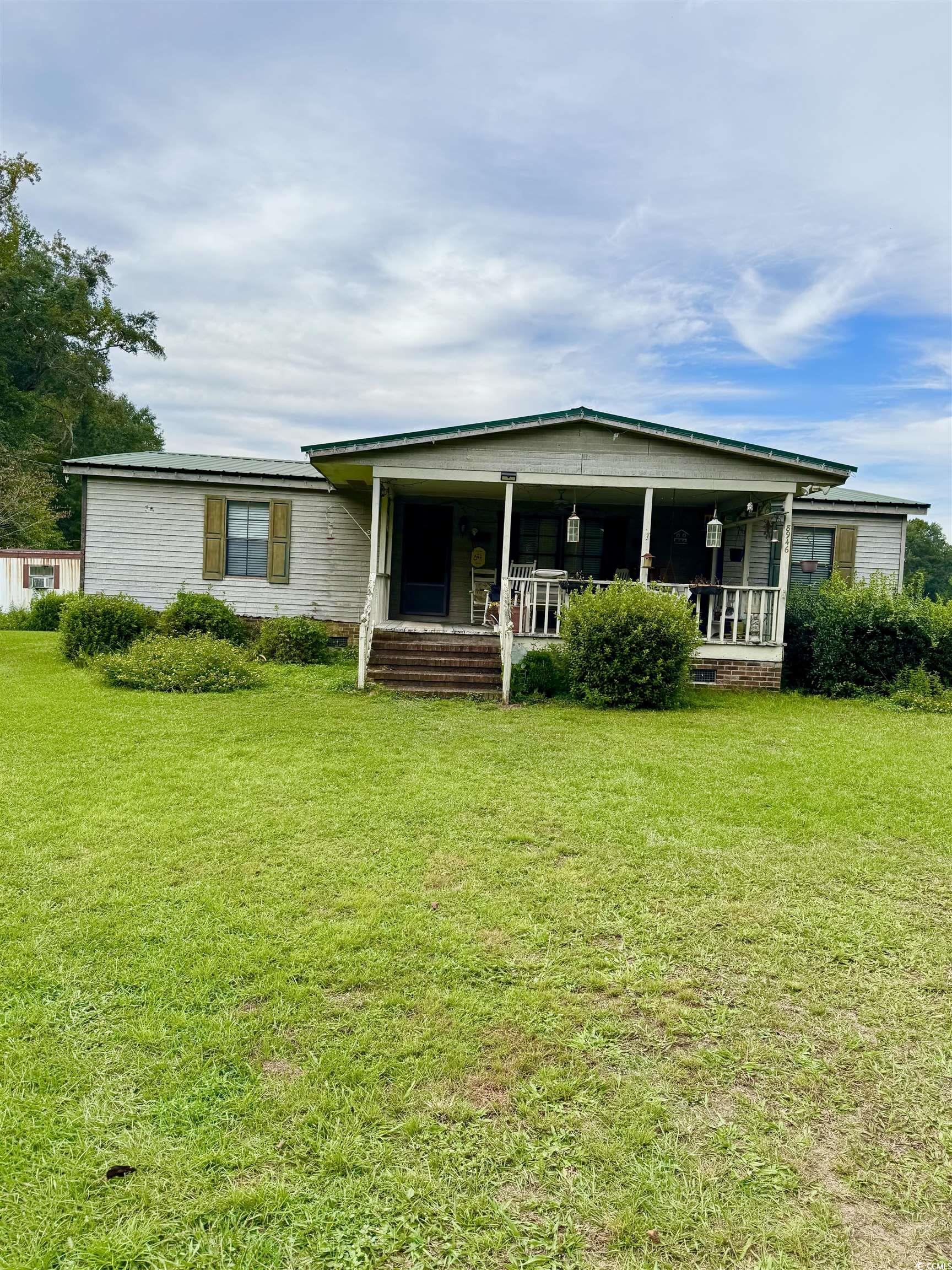 8946 Highmarket Street Georgetown, SC 29440 - Photo 2 of 6 Back of house featuring covered porch and a yard