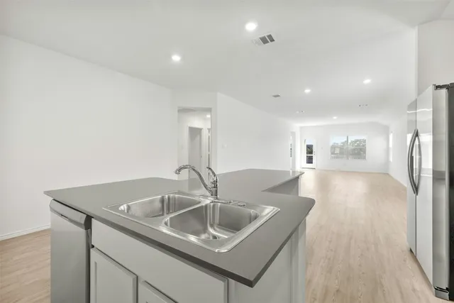 a kitchen with a sink cabinetry and wooden floor