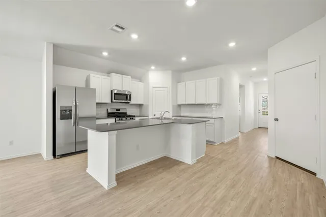 a kitchen with white cabinets and stainless steel appliances