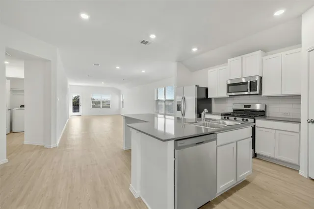 a kitchen with stainless steel appliances granite countertop a sink stove and refrigerator