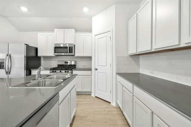 a kitchen with kitchen island white cabinets and stainless steel appliances