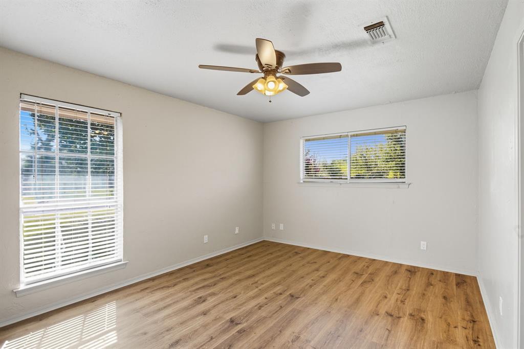 10304 Oak Creek Drive Greenville, TX 75402 - Photo 12 of 25 a view of an empty room with window and wooden floor