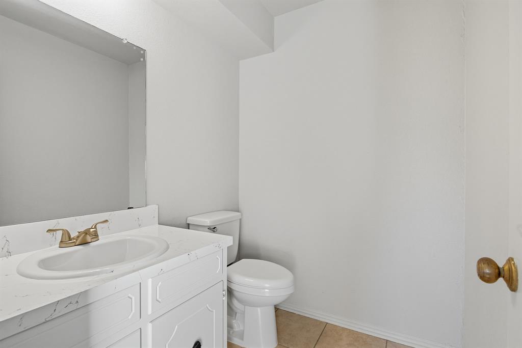 10304 Oak Creek Drive Greenville, TX 75402 - Photo 13 of 25 a bathroom with a sink and a toilet