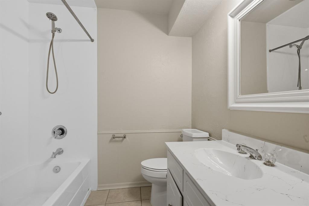 10304 Oak Creek Drive Greenville, TX 75402 - Photo 14 of 25 a bathroom with a sink a toilet and shower