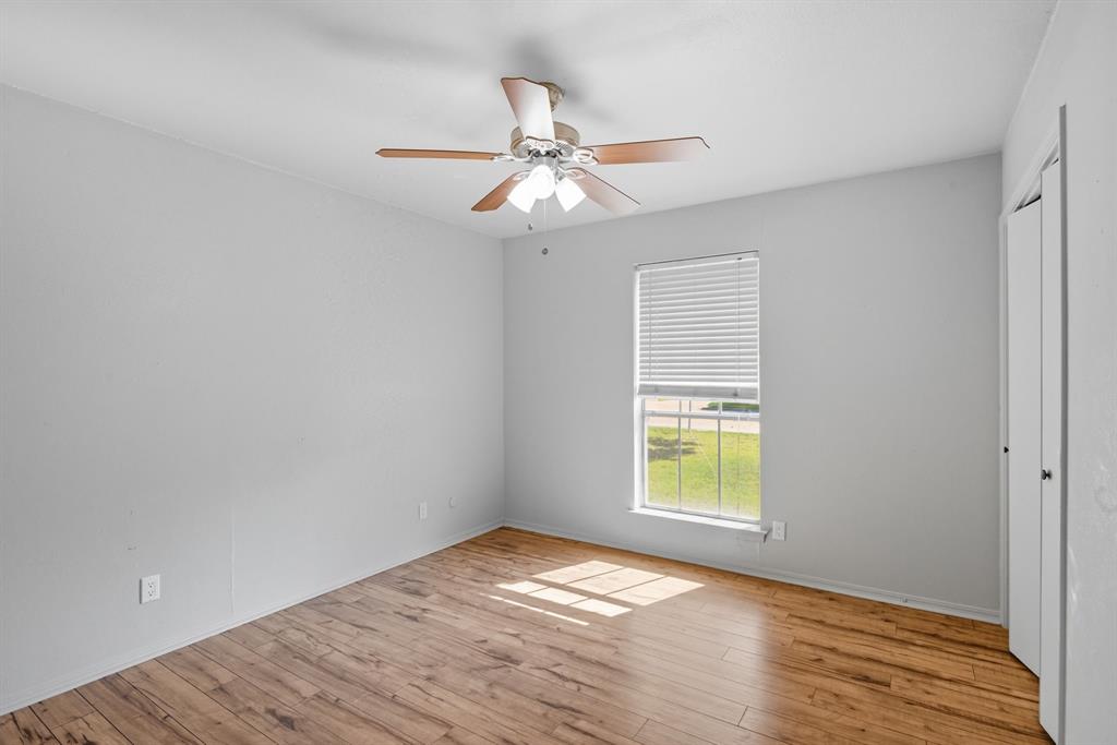 10304 Oak Creek Drive Greenville, TX 75402 - Photo 16 of 25 a view of an empty room with wooden floor and a window