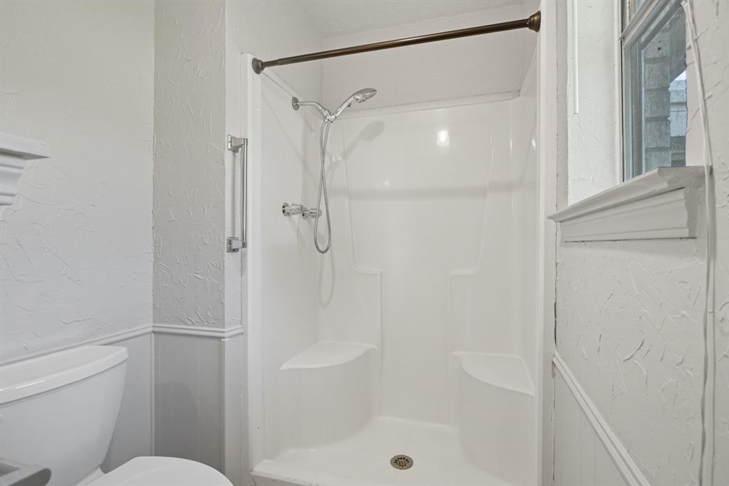 10304 Oak Creek Drive Greenville, TX 75402 - Photo 21 of 25 a bathroom with a shower and a toilet