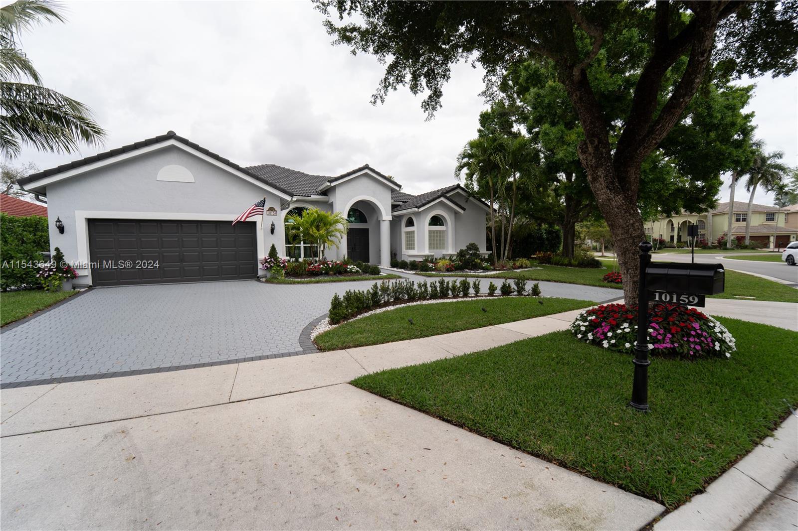 10159 Umberland Place Boca Raton, FL 33428 - Photo 1 of 25 a front view of a house with a garden and trees