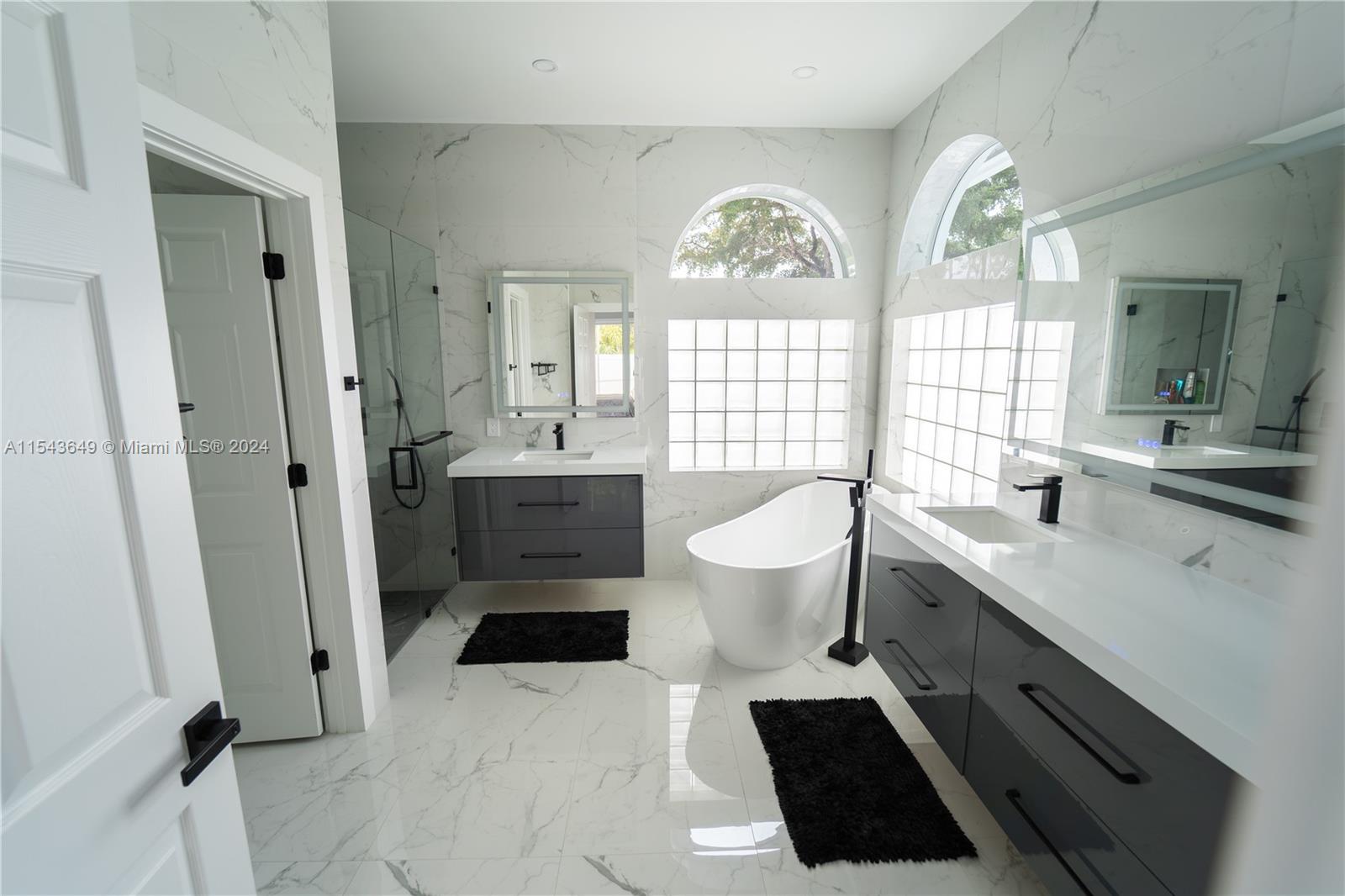 10159 Umberland Place Boca Raton, FL 33428 - Photo 14 of 25 a spacious bathroom with a double vanity sink a toilet a mirror and window