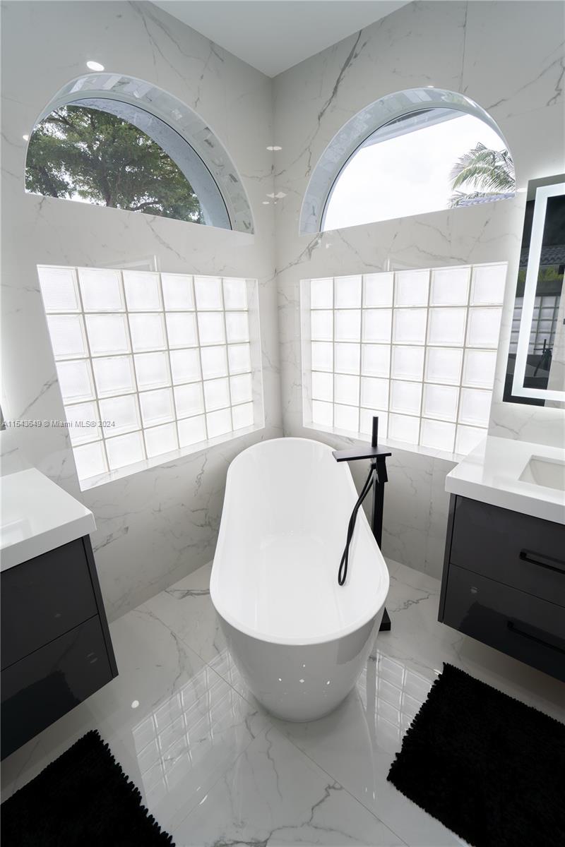 10159 Umberland Place Boca Raton, FL 33428 - Photo 15 of 25 a bathroom with a bathtub and window