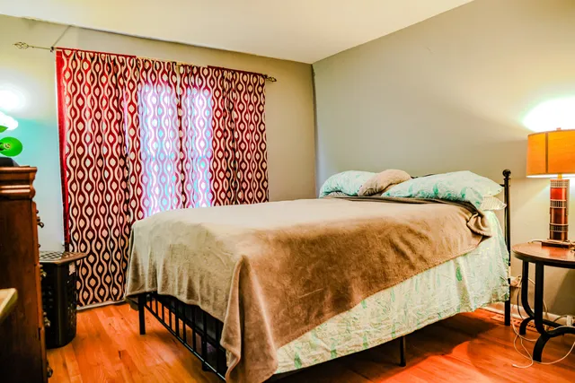 a bedroom with a bed and wooden floor