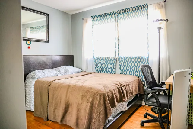 a bedroom with a bed and wooden floor