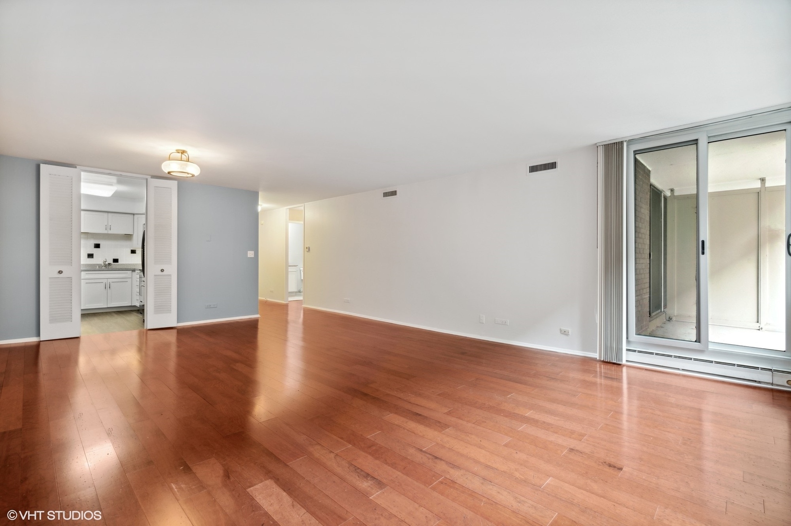201 East Chestnut Street, Unit 10E Chicago, IL 60611 - Photo 3 of 12 a view of an empty room with window and wooden floor