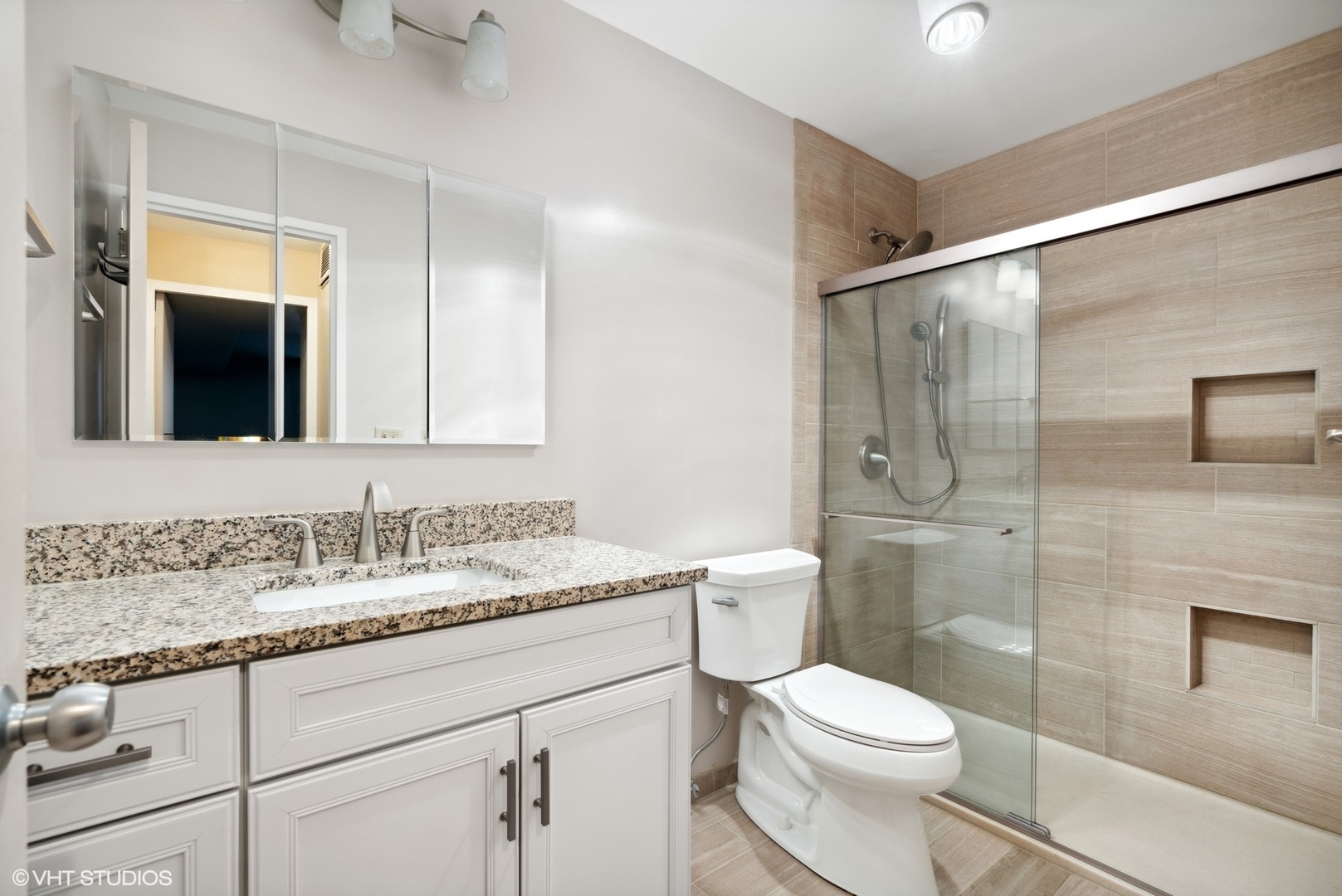 201 East Chestnut Street, Unit 10E Chicago, IL 60611 - Photo 6 of 12 a bathroom with a sink toilet vanity and shower