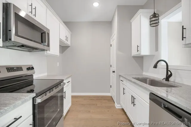 a kitchen with stainless steel appliances granite countertop a sink and a stove