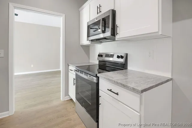 a kitchen with stainless steel appliances granite countertop a sink and a microwave