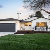 a front view of a house with a garden and yard
