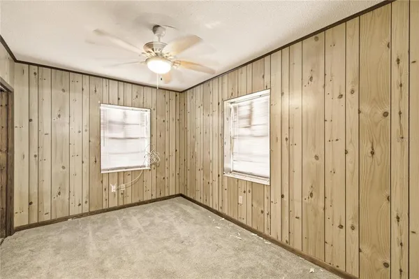 an empty room with windows and closet area