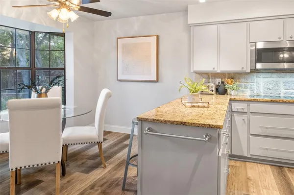 a kitchen with granite countertop cabinets and chair