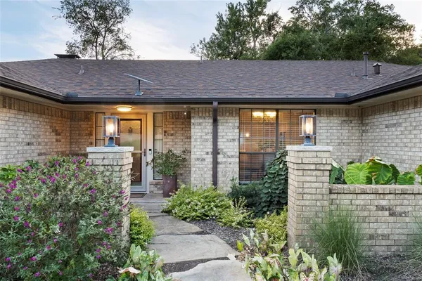 a view of house with garden and outdoor seating