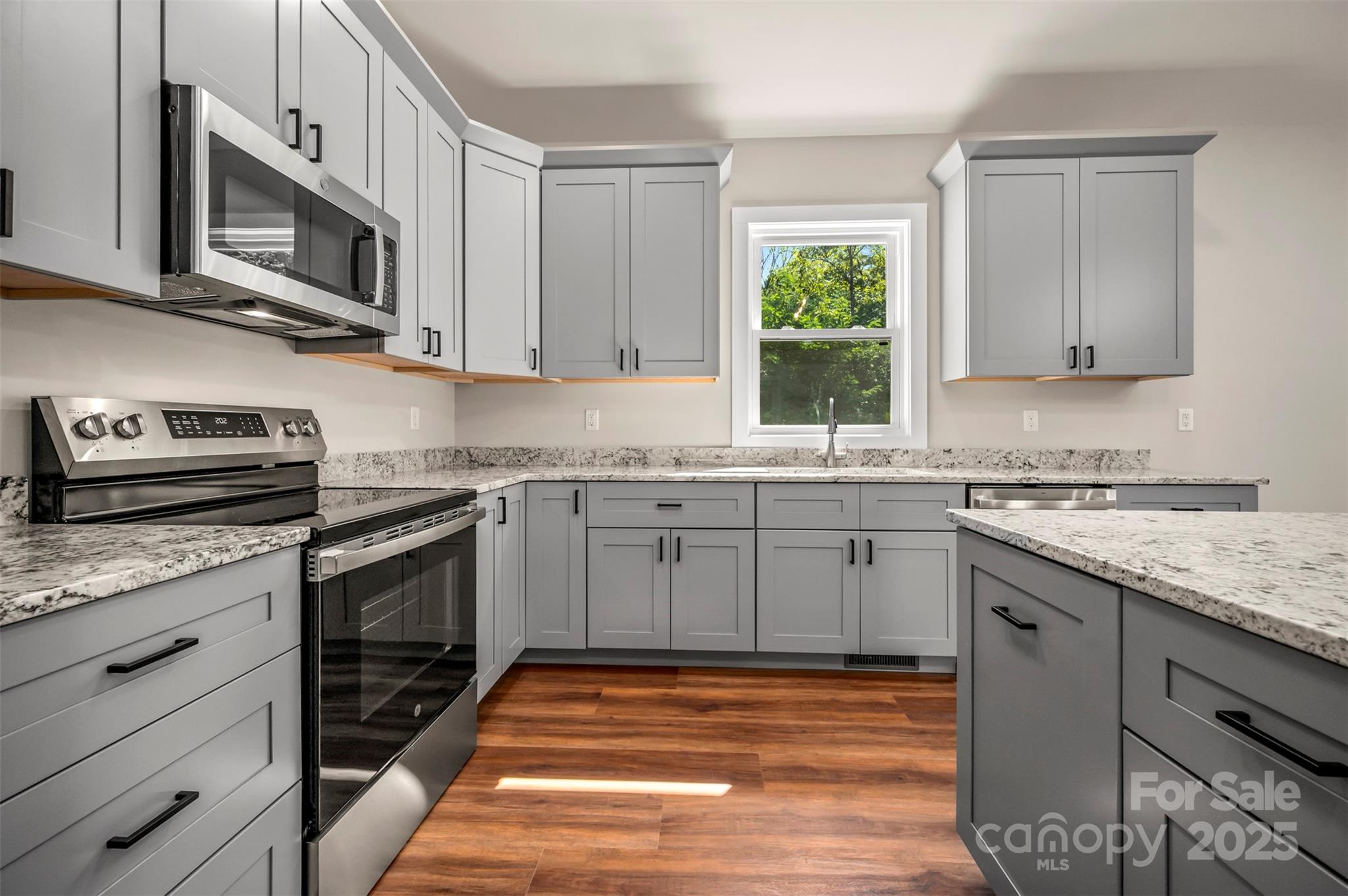 213 Calhoun Street Hendersonville, NC 28739 - Photo 11 of 32 a kitchen with granite countertop a sink cabinets stainless steel appliances and a window