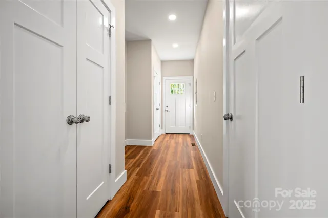 a view of a hallway with wooden floor and staircase