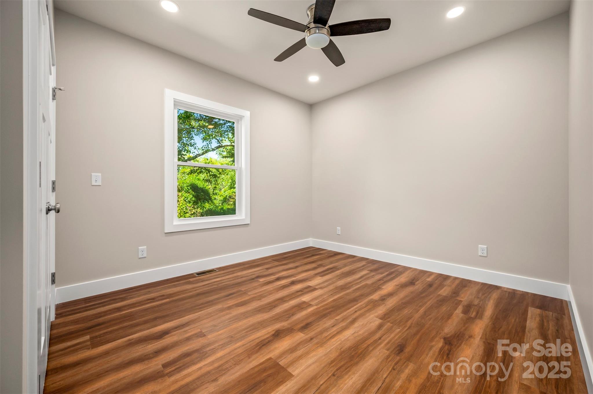 213 Calhoun Street Hendersonville, NC 28739 - Photo 22 of 32 an empty room with a window and a ceiling fan