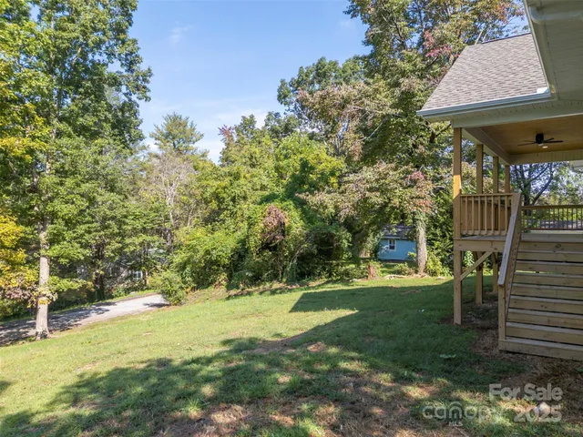 a view of swimming pool with lawn chairs and plants
