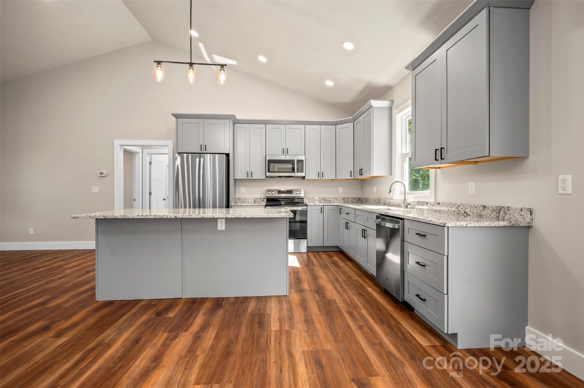 213 Calhoun Street Hendersonville, NC 28739 - Photo 9 of 32 a kitchen with kitchen island granite countertop a sink cabinets and stainless steel appliances
