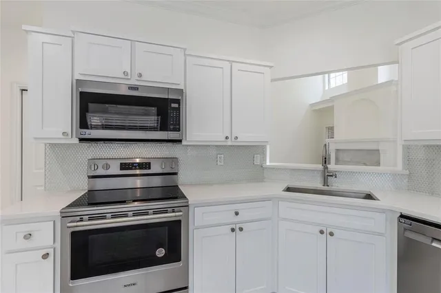 a kitchen with cabinets stainless steel appliances a sink and a microwave