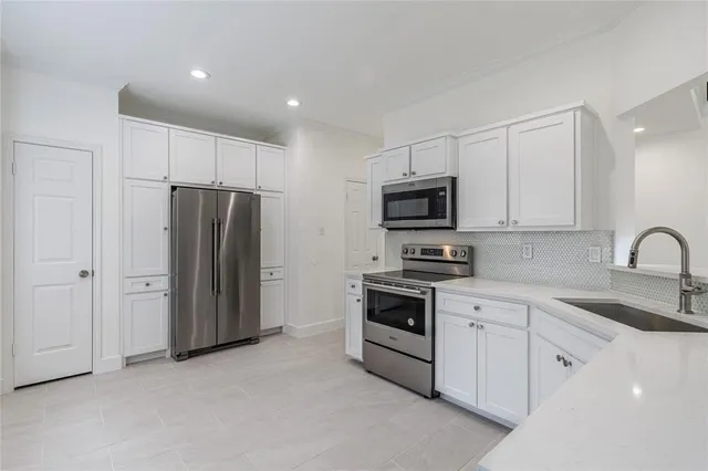 a kitchen with stainless steel appliances granite countertop white cabinets and refrigerator
