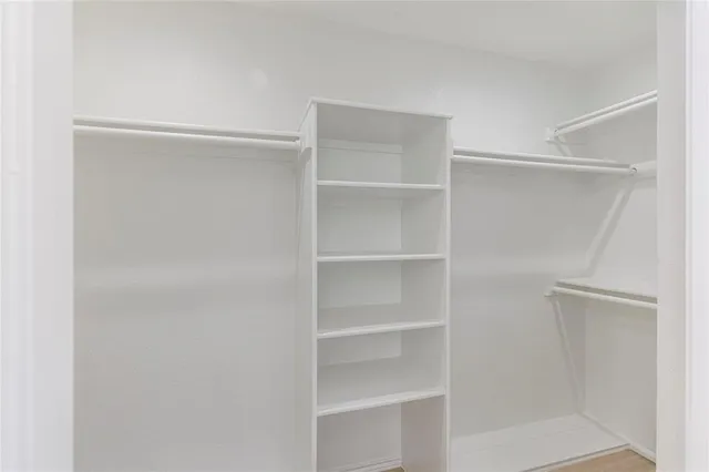 a view of walk in closet with empty racks