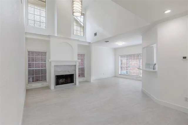 an empty room with windows and fireplace