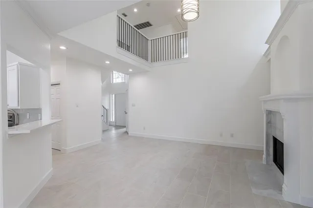an empty room with fireplace and windows