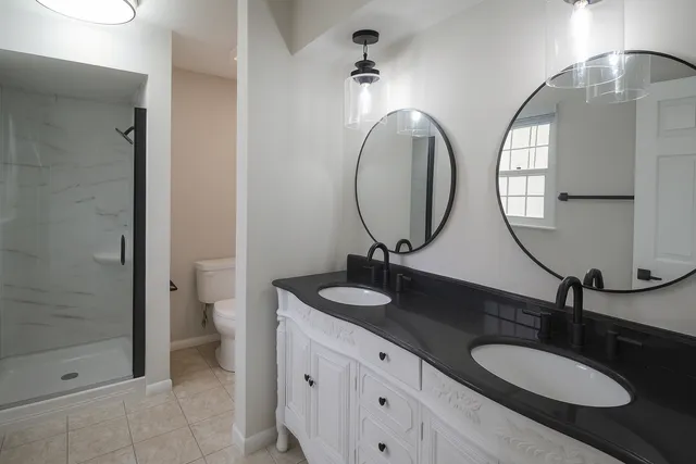a bathroom with a double vanity sink and a mirror
