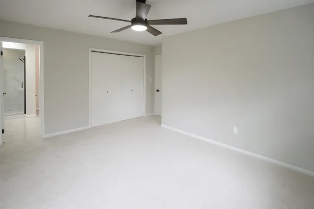an empty room with a window and a fan