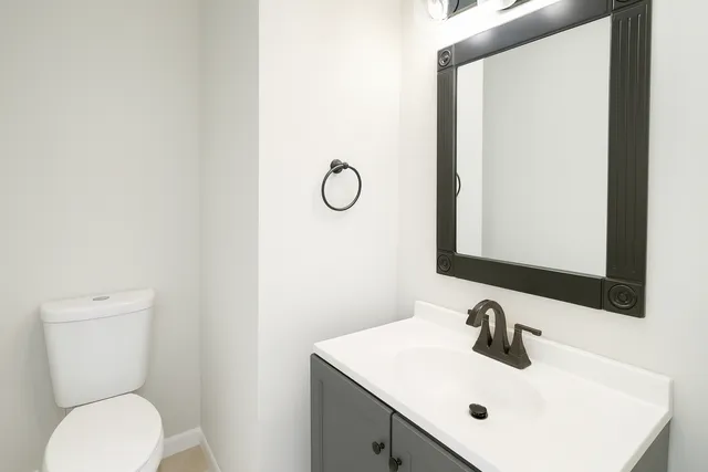 a bathroom with a sink toilet and mirror