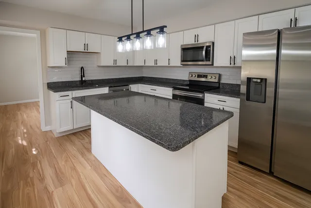 a kitchen with a center island and stainless steel appliances