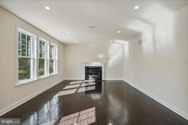 a view of a livingroom with wooden floor and a fireplace