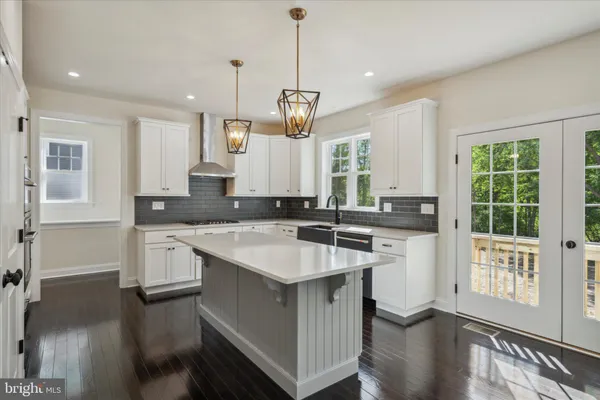 a kitchen with kitchen island granite countertop a sink stove and wooden floor