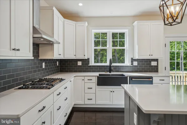 a kitchen with white cabinets and appliances