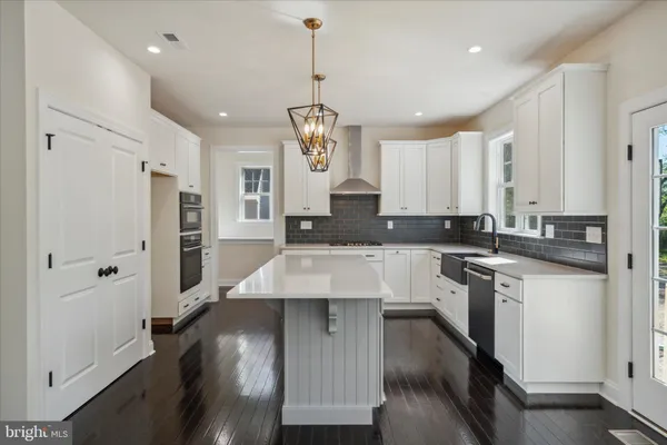 a kitchen with stainless steel appliances kitchen island granite countertop a stove refrigerator and cabinets