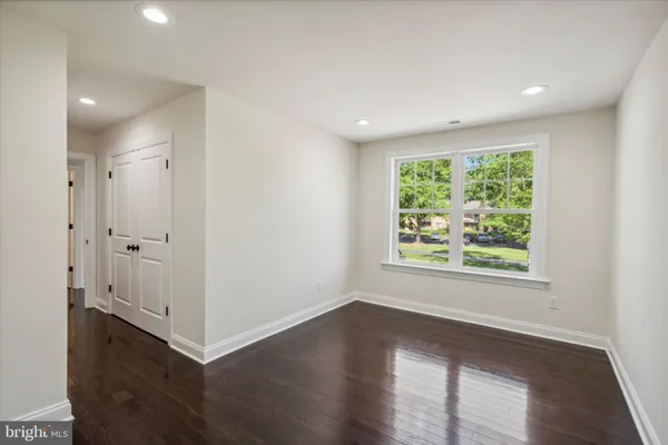 an empty room with wooden floor and a window