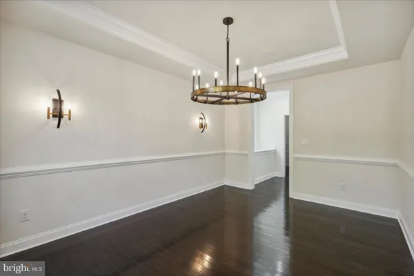 a view of a room with wooden floor chandelier closet and windows