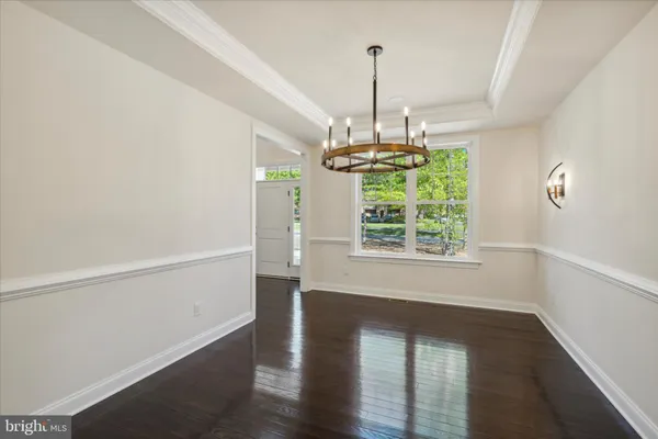 a view of empty room with wooden floor fan and window
